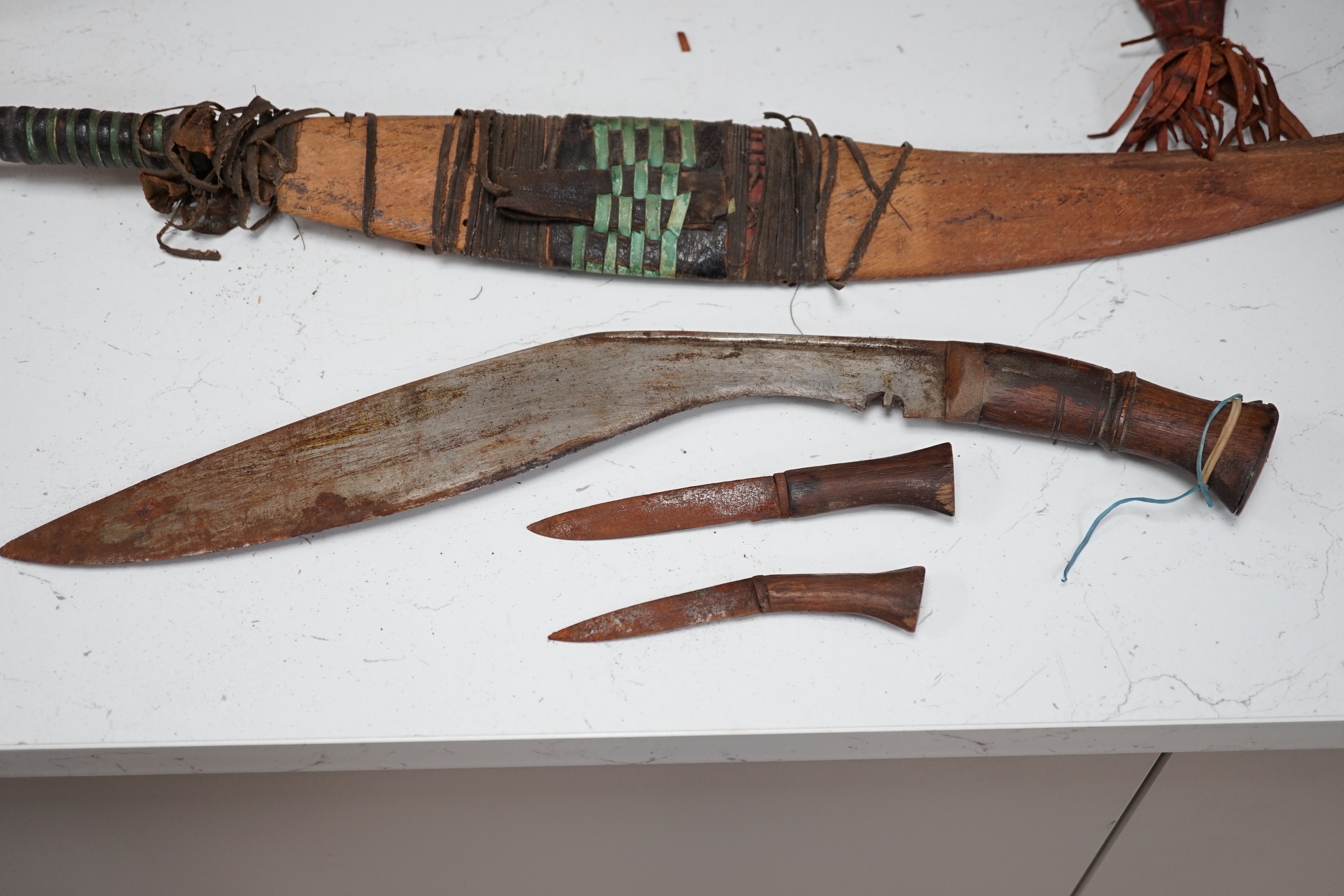 A kukri, a long dagger and sheath, a mace, and two African ebony busts